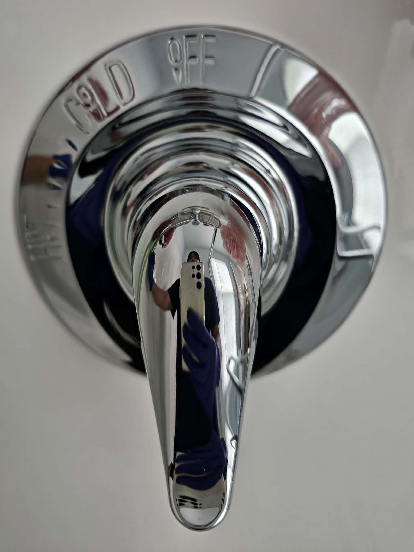 After picture detailing a perfectly polished, mirror-finish chrome shower valve handle cleaned by Mrs. Sparkle Cleaning Company LLC.